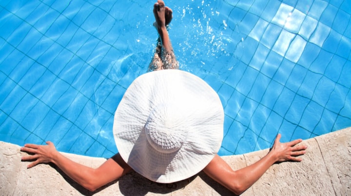 woman in pool wearing hat