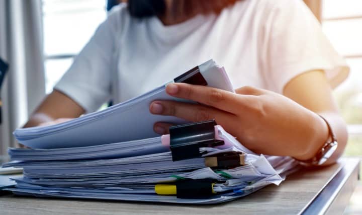 woman with stack of papers